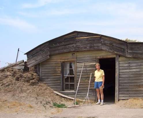 Pretty model posing in front of the sod house